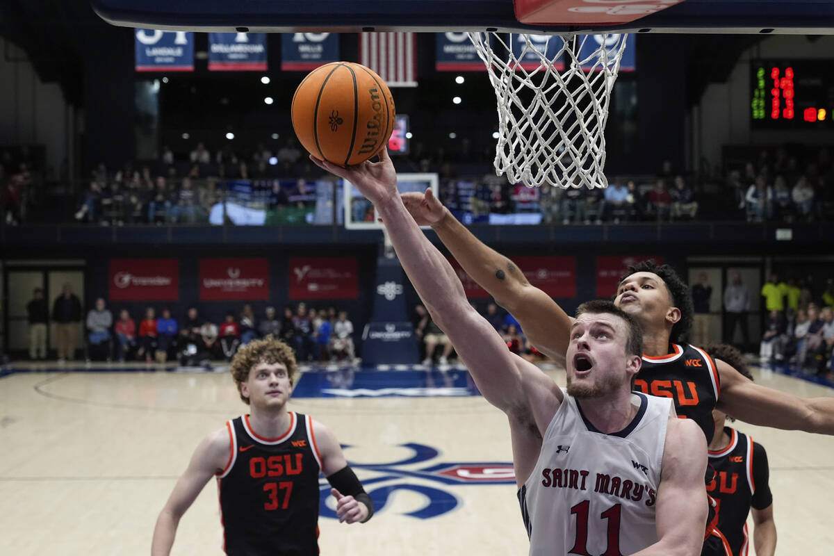 Saint Mary's center Mitchell Saxen (11) shoots while defended by Oregon State forward Michael R ...