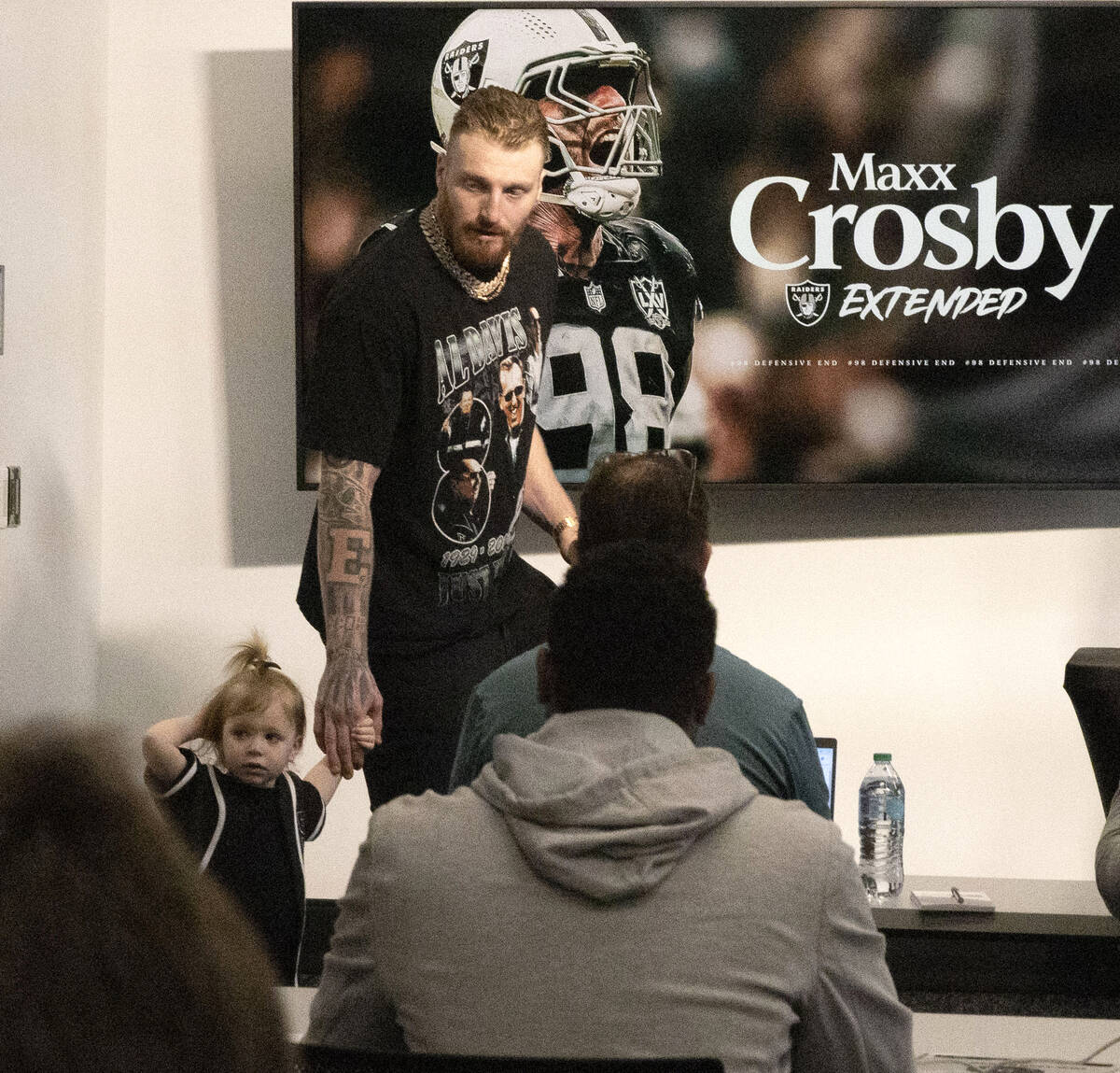 Raiders defensive end Maxx Crosby, right, and his daughter Ella, arrive at a news conference an ...