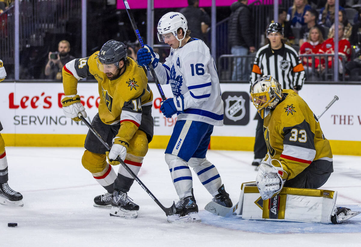 Golden Knights defenseman Nicolas Hague (14) deflects a shot intended for Toronto Maple Leafs r ...