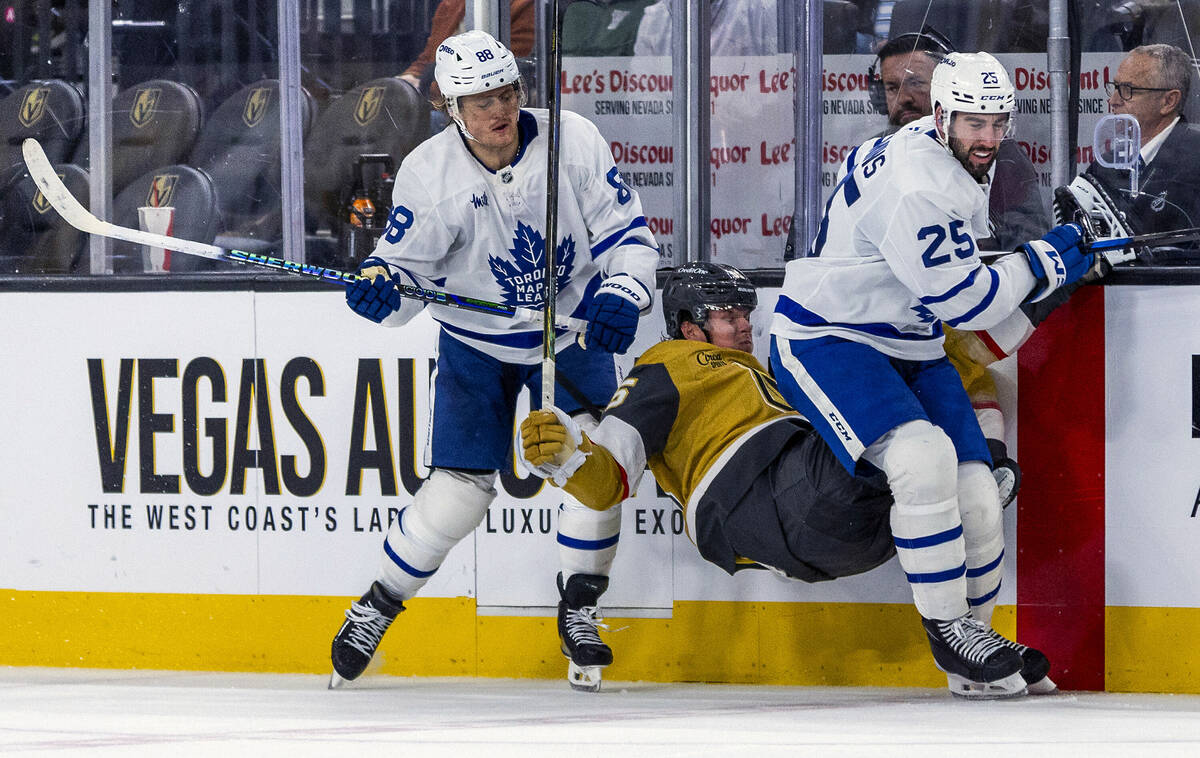 Golden Knights right wing Victor Olofsson (95) is taken out by a double hit from Toronto Maple ...