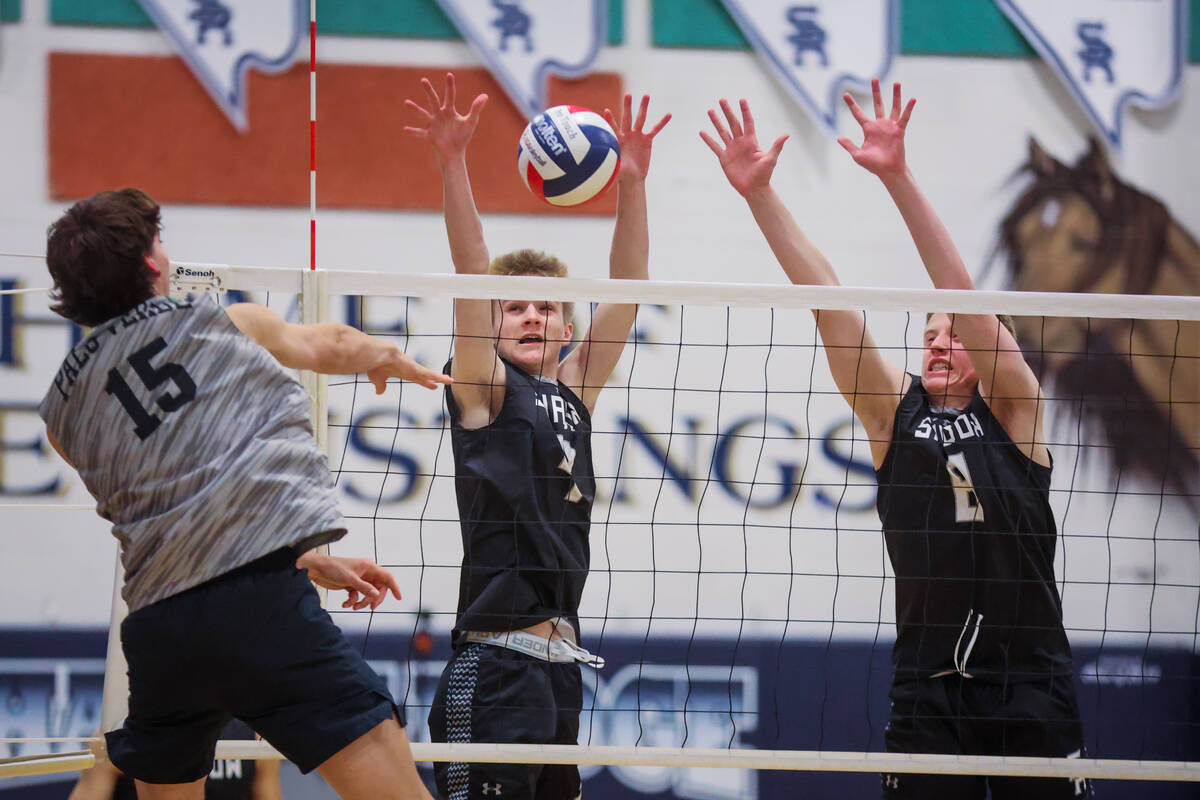 Shadow Ridge opposite hitter Tanner Dixon (4) and middle blocker Max Romzek (8) block a hit by ...