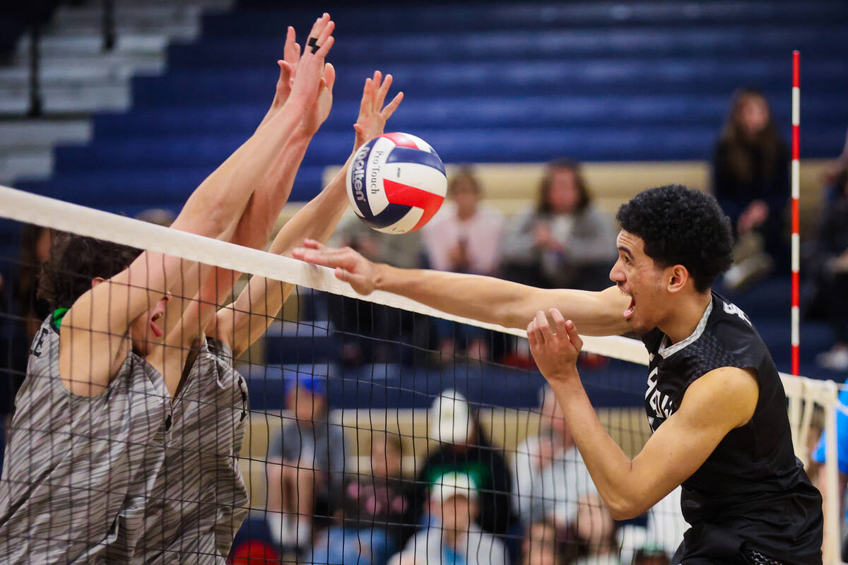 Shadow Ridge setter Kingston Jerome (1) meets a wall of hands as he attempts to pass the ball o ...