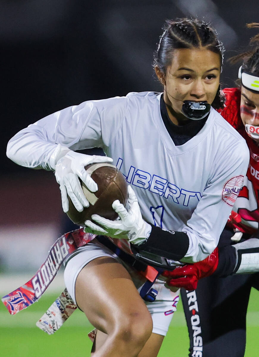 Liberty wide receiver Trishelle Tucay (1) gets her flag yanked during a run with the ball at a ...