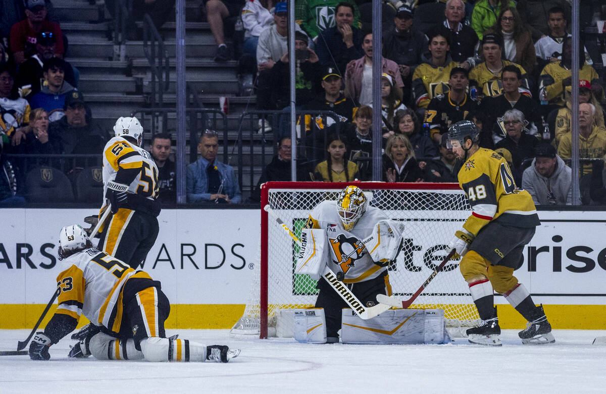 Pittsburgh Penguins goaltender Alex Nedeljkovic (39) deflects a shot with Golden Knights center ...