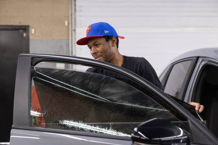 Christian Hall applies tint to a passenger side window of a Honda at Affordable Window Tint on ...