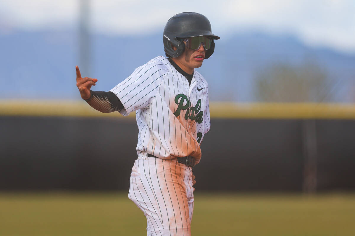 Palo Verde infielder Luke Herrera signals to his teammates while on third base during a high sc ...