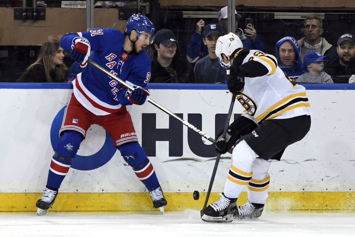 New York Rangers' Reilly Smith, left, and Boston Bruins' Elias Lindholm, right, battle for the ...