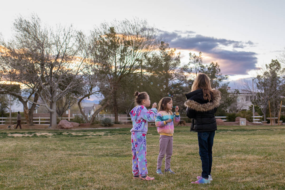 Yoyo Wang, 6, center, blows bubbles with her best friend Love Davis, 6, during a vigil and bubb ...