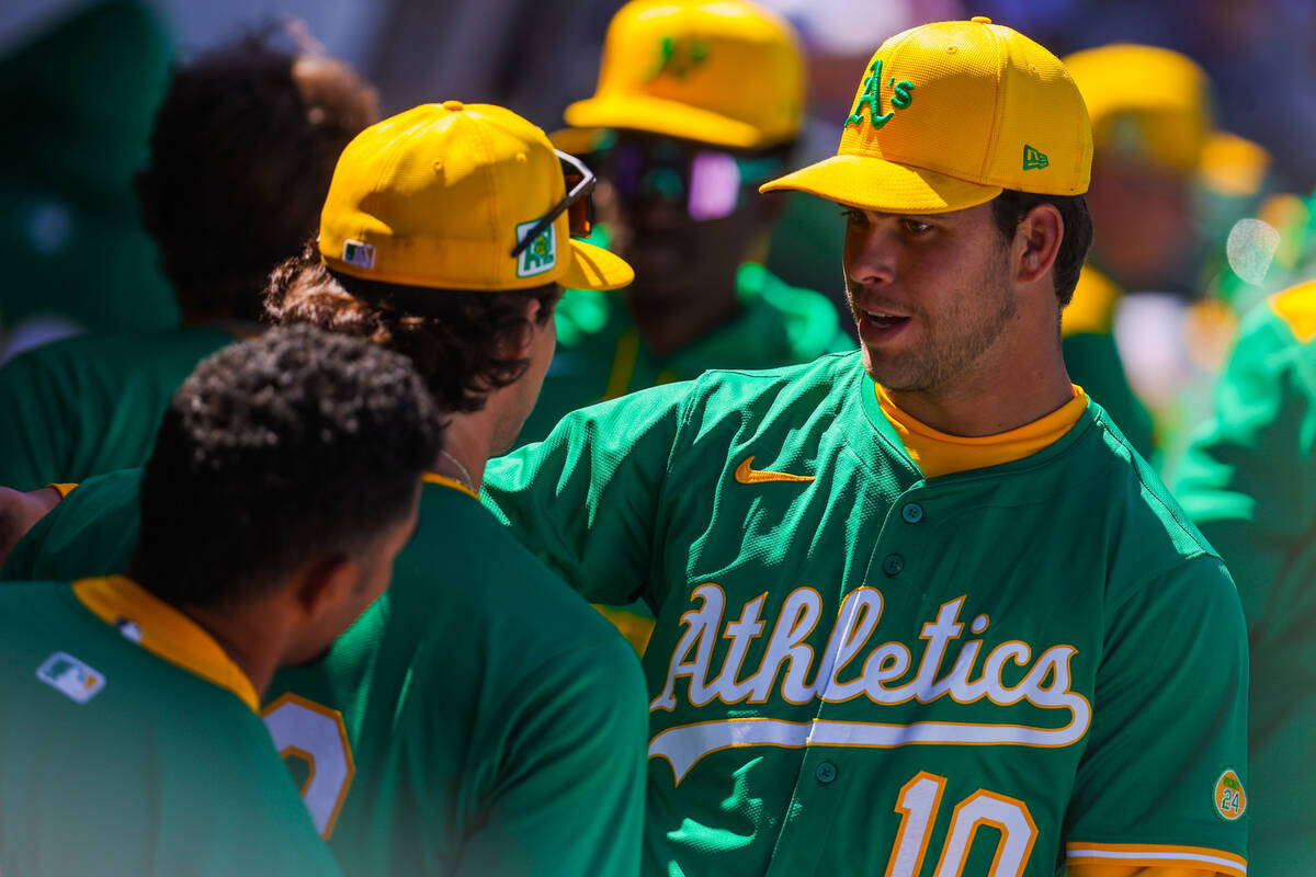 Athletics infielder Max Muncy greets players as they come back into the dugout during a Big Lea ...