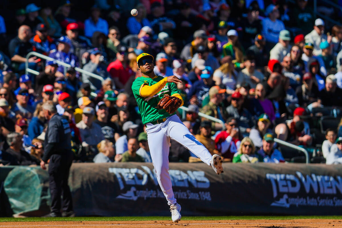 Athletics infielder Darell Hernaiz passes the ball to a teammate during a Big League Weekend ba ...
