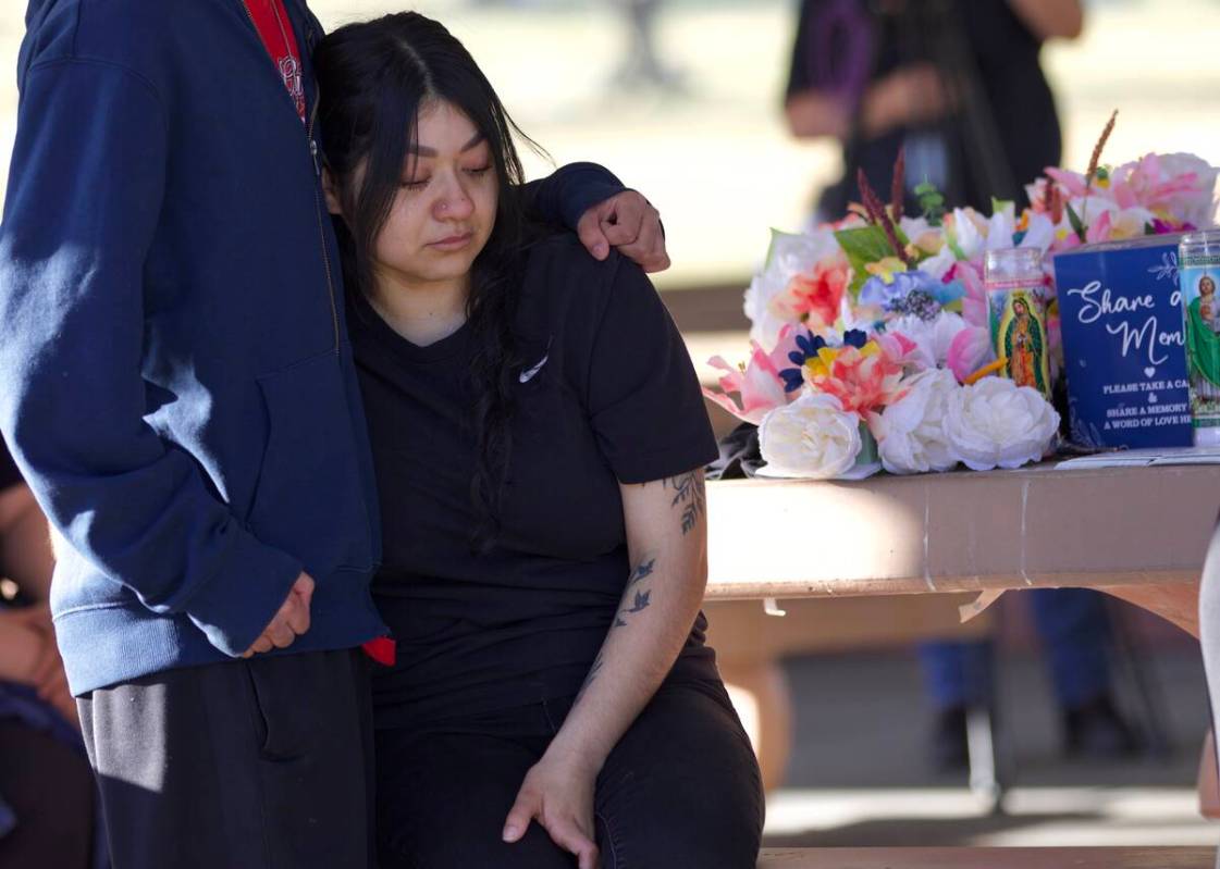 A loved one comforts Jennifer Zamora during a candlelight vigil and balloon release to commemor ...