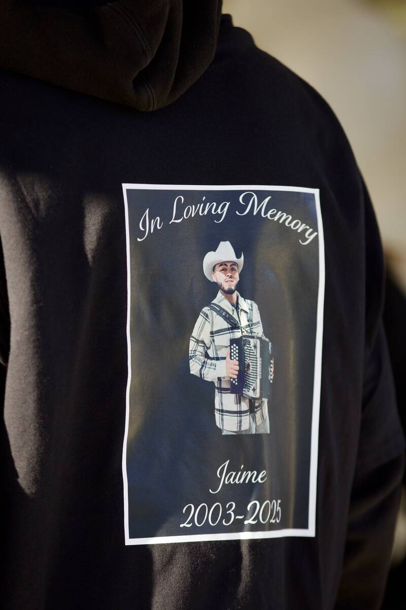 An attendee wears a shirt with a picture of Jaime Zamora on it during a candlelight vigil and b ...
