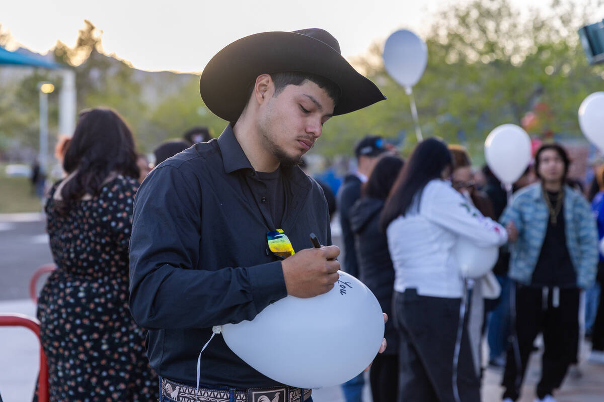 Juan Carillo writes a message to Jaime Zamora during a candle-lighting ceremony and balloon rel ...