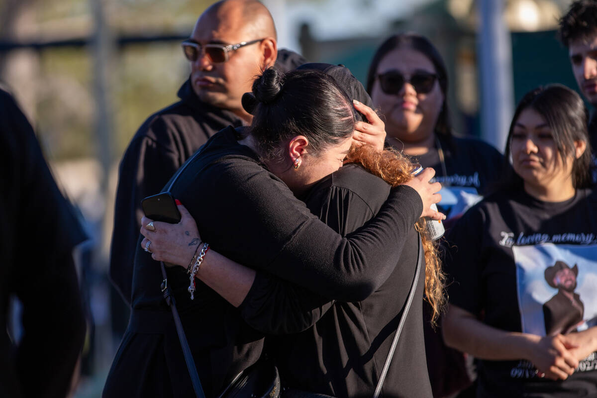 Loved ones comfort each other during a candle-lighting ceremony and balloon release to commemor ...