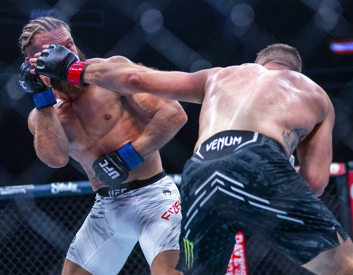 Rafael Fiziev takes a punch from Justin Gaethje during their lightweight fight at UFC 313 in th ...