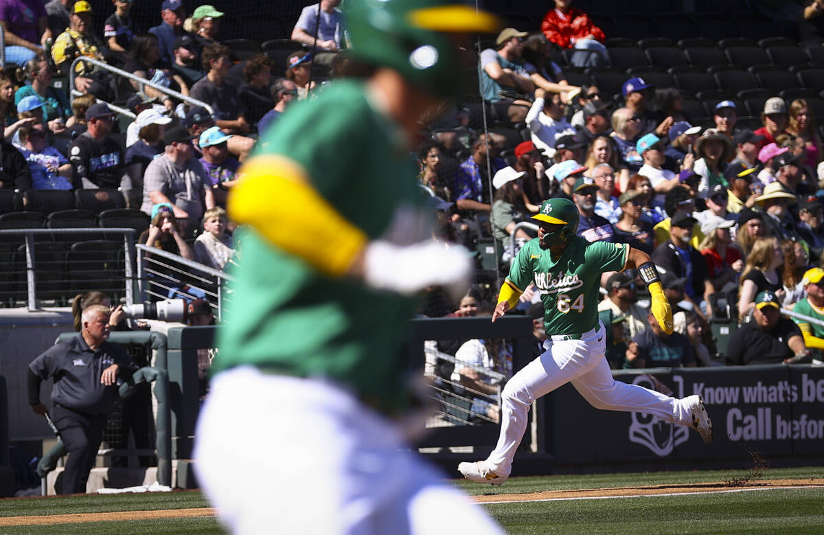 Athletics catcher Jhonny Pereda (64) heads for home plate to score a run against the Arizona Di ...