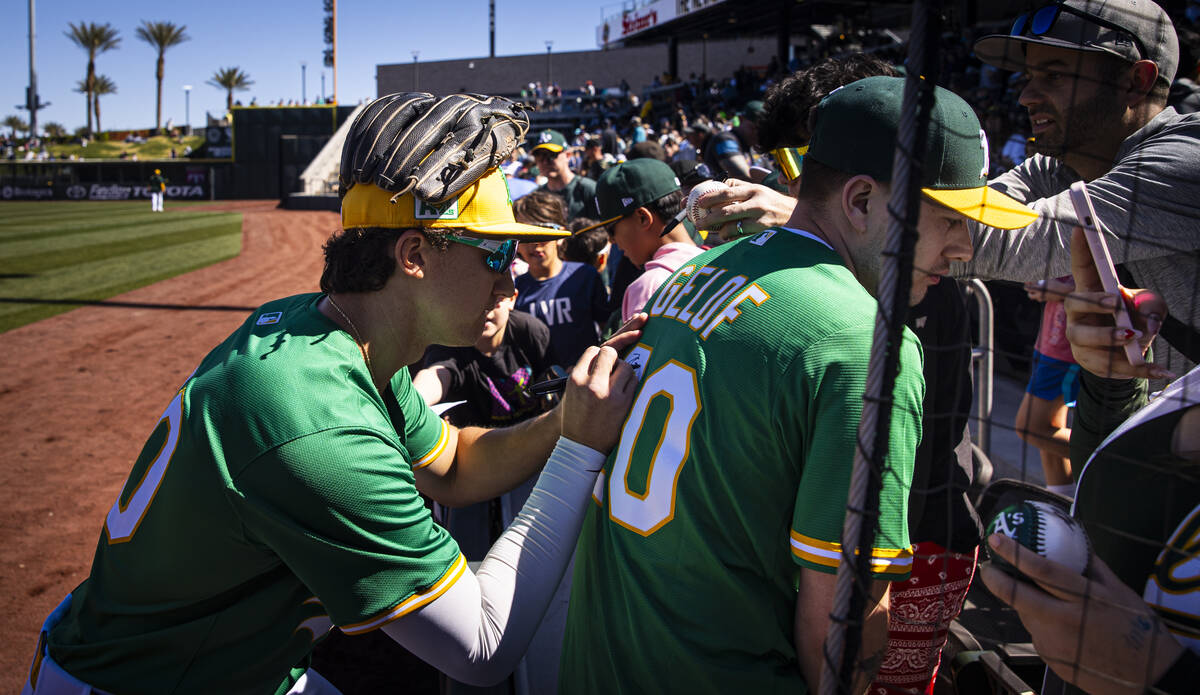 Athletics second baseman Zack Gelof signs a jersey before a Big League Weekend baseball game ag ...