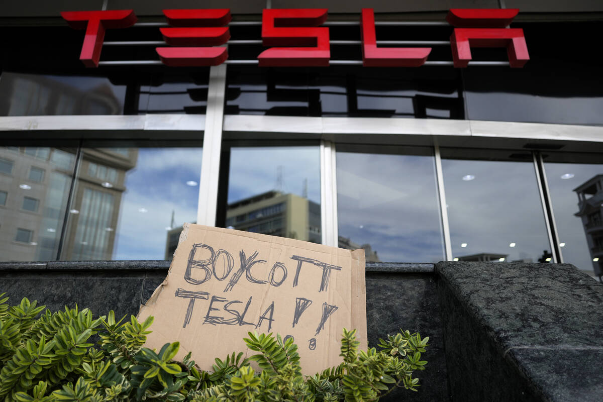 A banner is left outside a Tesla showroom during a demonstration, in Lisbon, Sunday, March 9, 2 ...