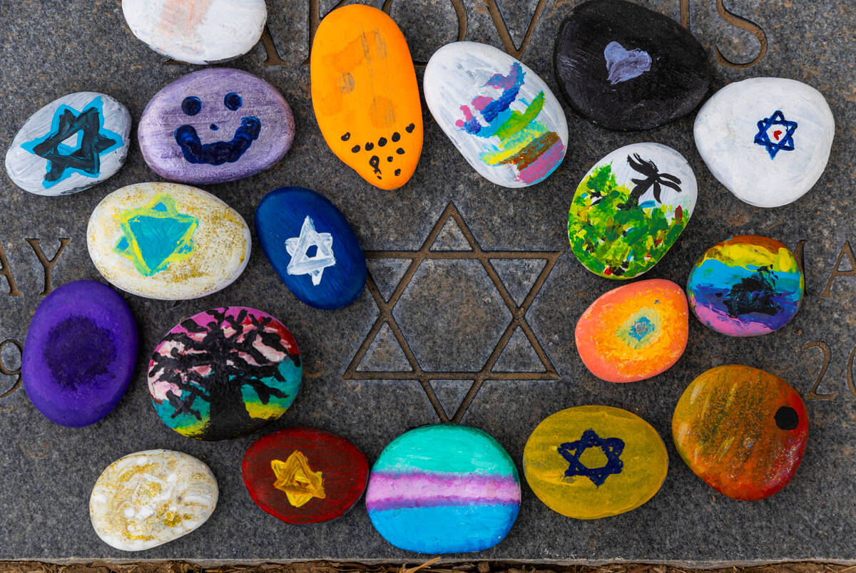 Painted stones by children await distribution as the local Jewish community marks the graves of ...