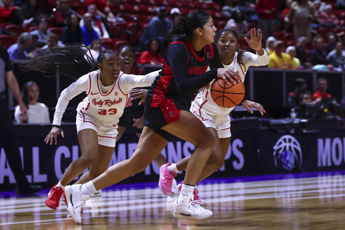 UNLV Lady Rebels guards Amarachi Kimpson (33) and Aaliyah Alexander (25) try to foul San Diego ...