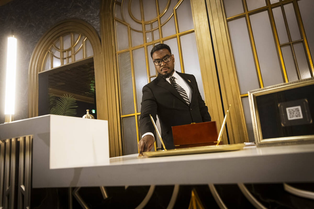 Byron Smith, a performer with the John Wick Experience, shows a gold coin in The Continental lo ...