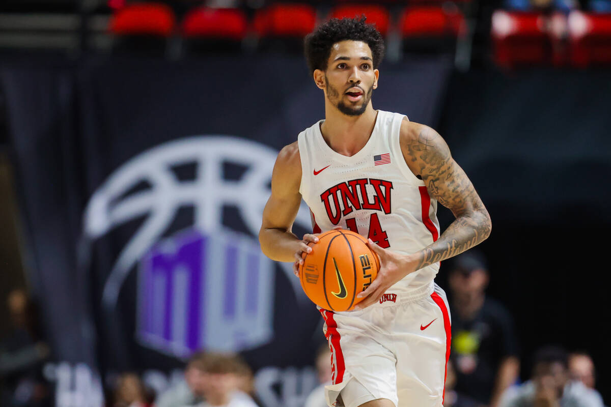 Rebels guard Jailen Bedford looks for a teammate to pass the ball to during a Mountain West men ...