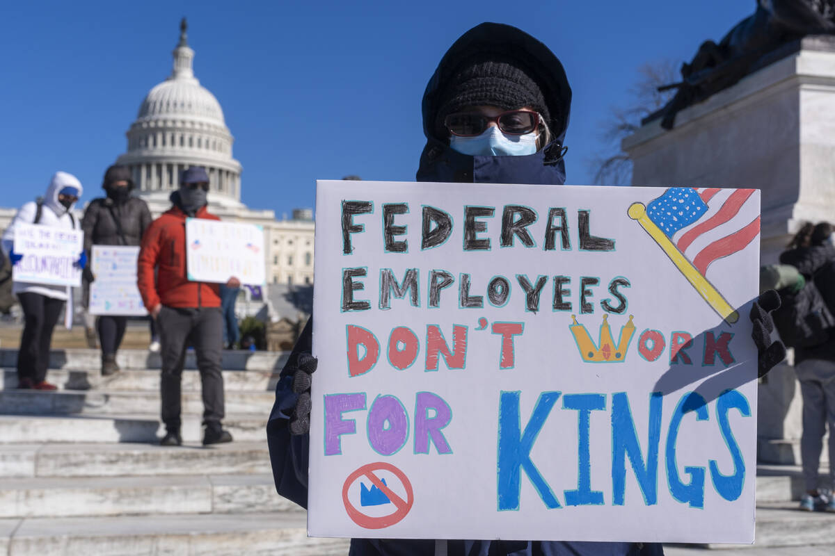A federal employee, who asked not to use their name for fears over losing their job, protests w ...