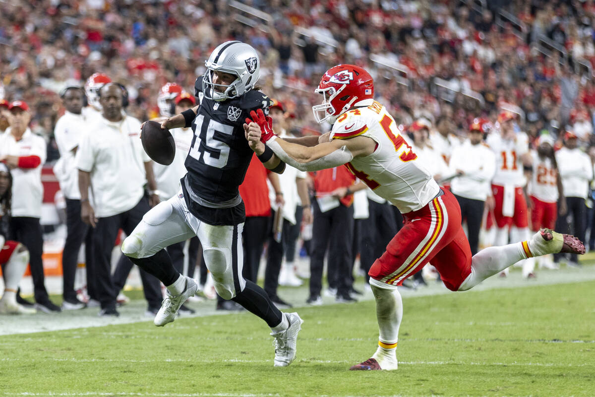 Raiders quarterback Gardner Minshew (15) is pushed out of bounds by Kansas City Chiefs lineback ...