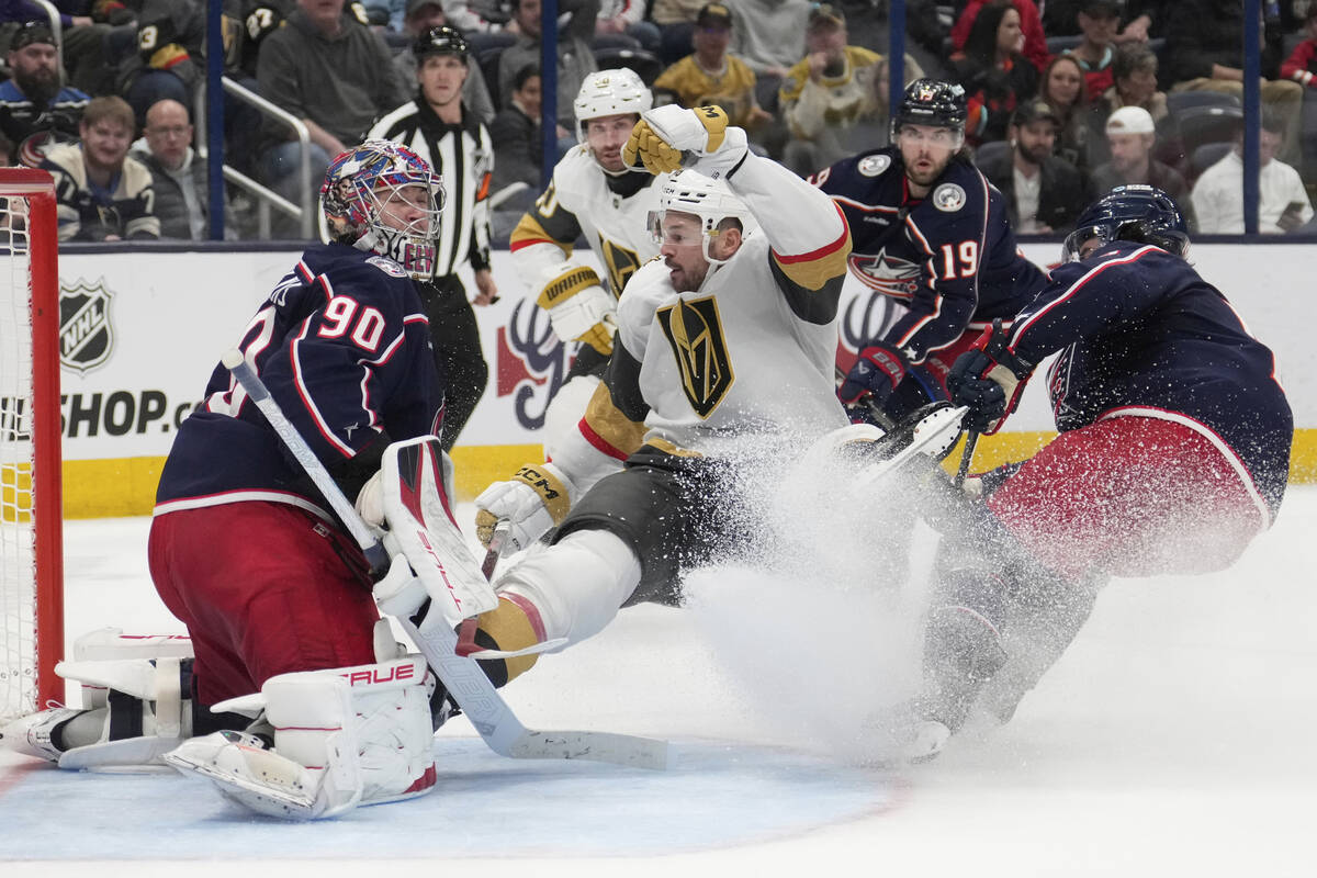 Vegas Golden Knights center Tomas Hertl, center, falls into Columbus Blue Jackets goaltender El ...