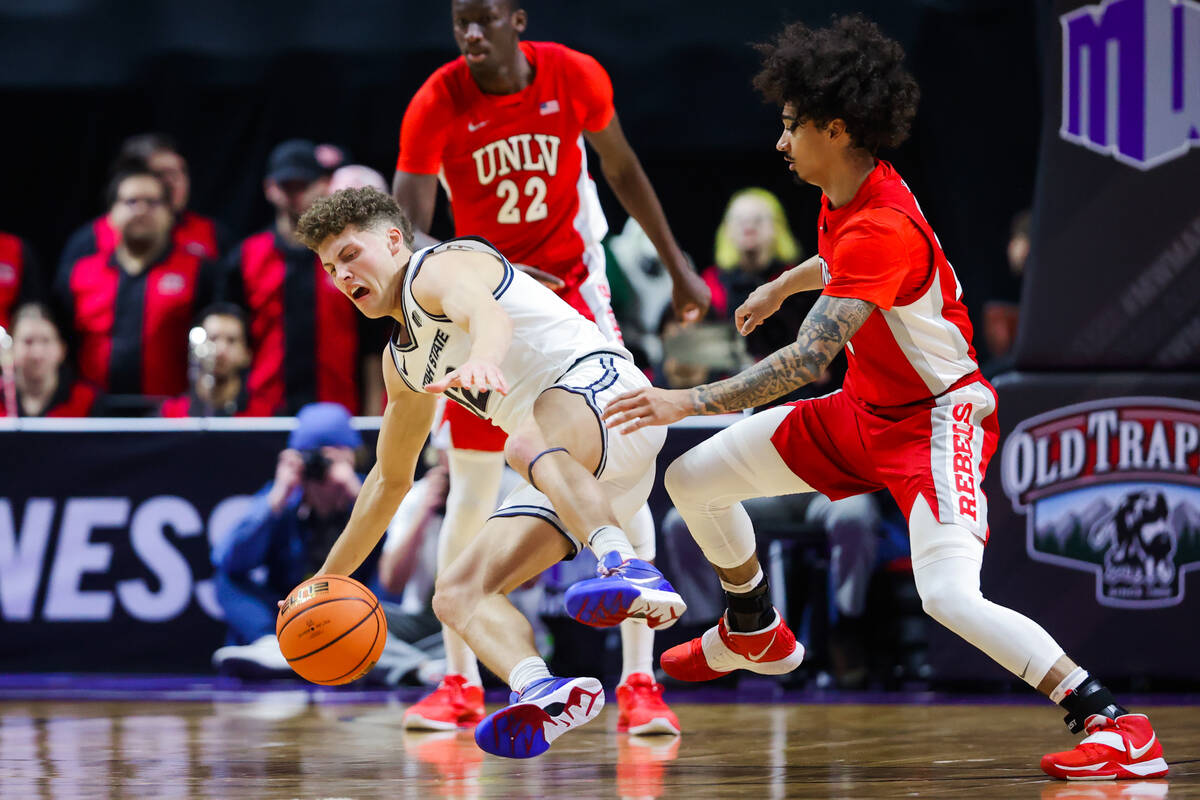 Utah State Aggies guard Mason Falslev (12) loses the ball as he trips over Rebels guard Brookly ...