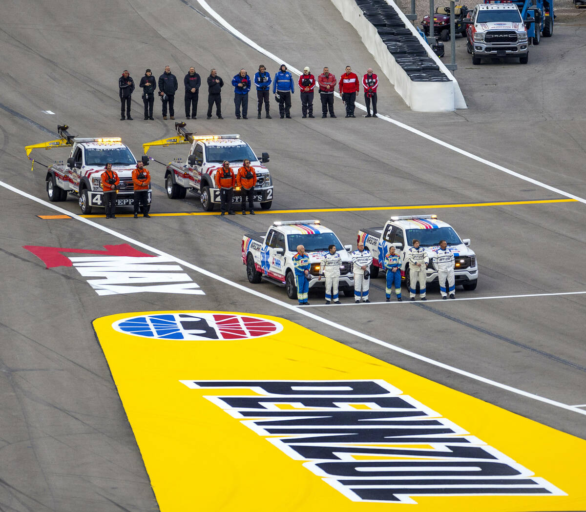Track officials stand for the National Anthem before the start of the NASCAR Craftsman Truck Se ...