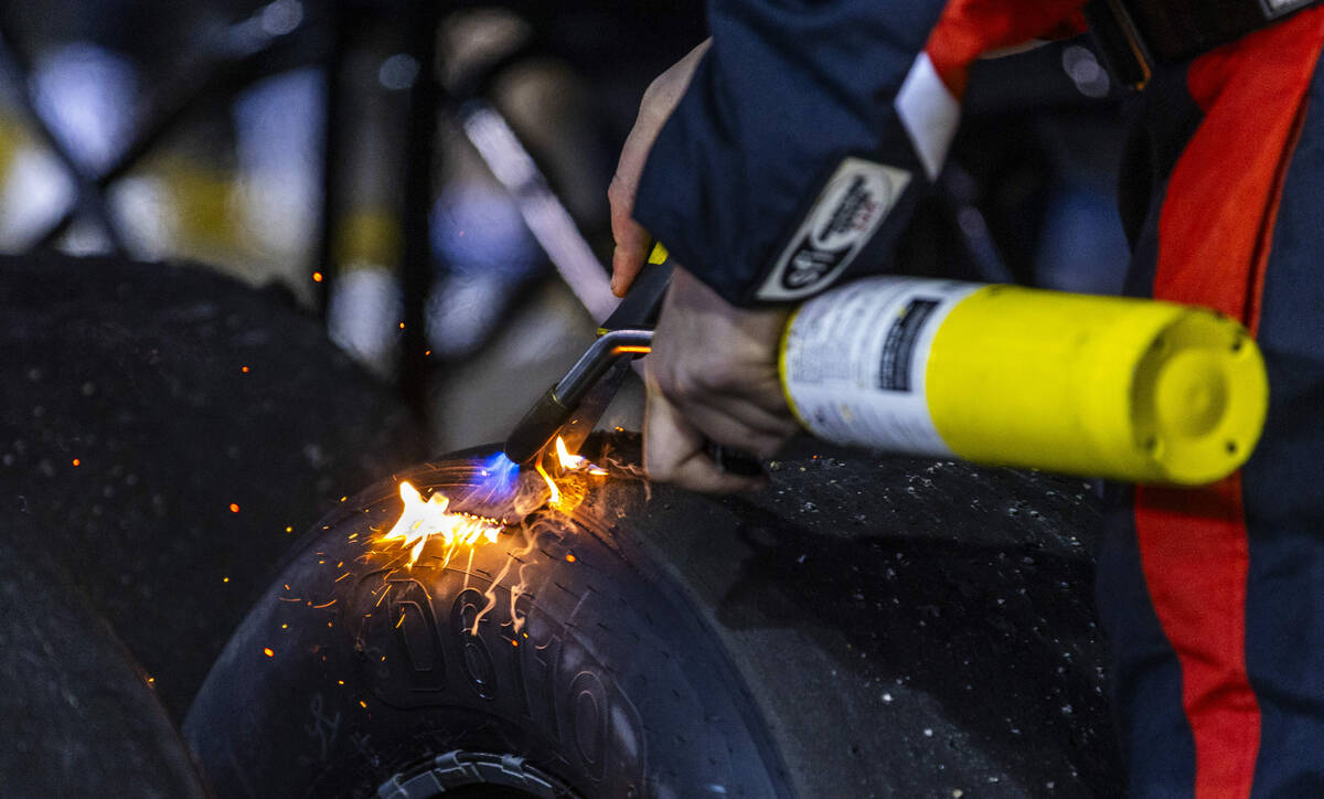 A crew member scrapes tires in the pits during the NASCAR Craftsman Truck Series Ecosave 200 ra ...