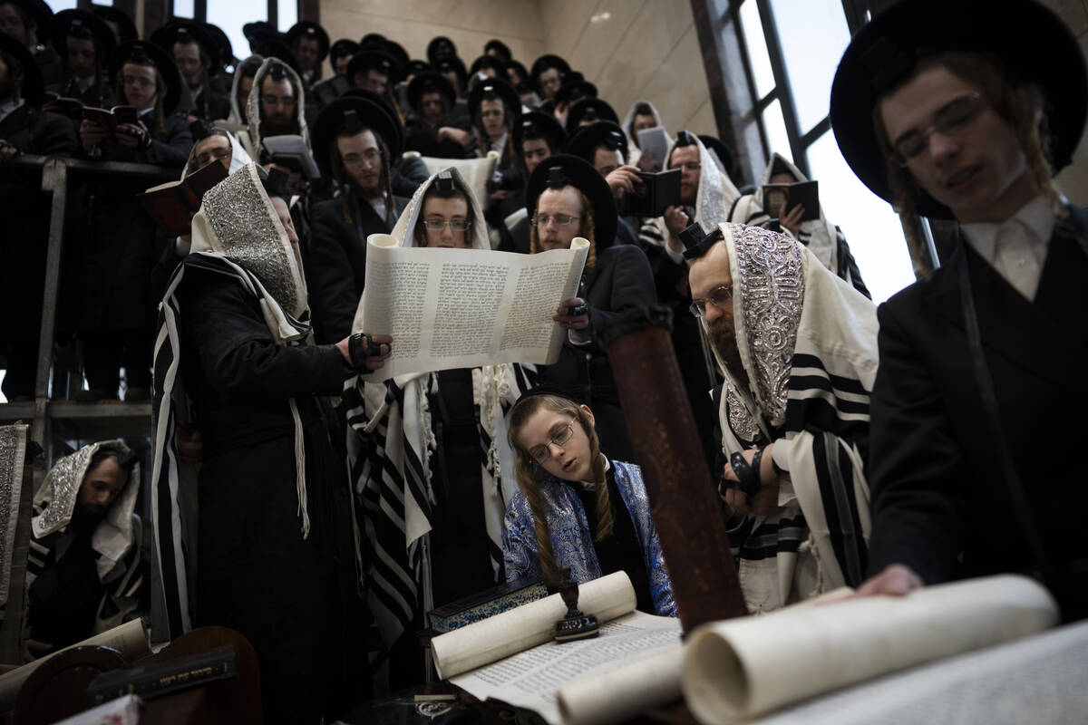 Jewish ultra-Orthodox men and children, some wearing costumes read the Book of Esther, which te ...