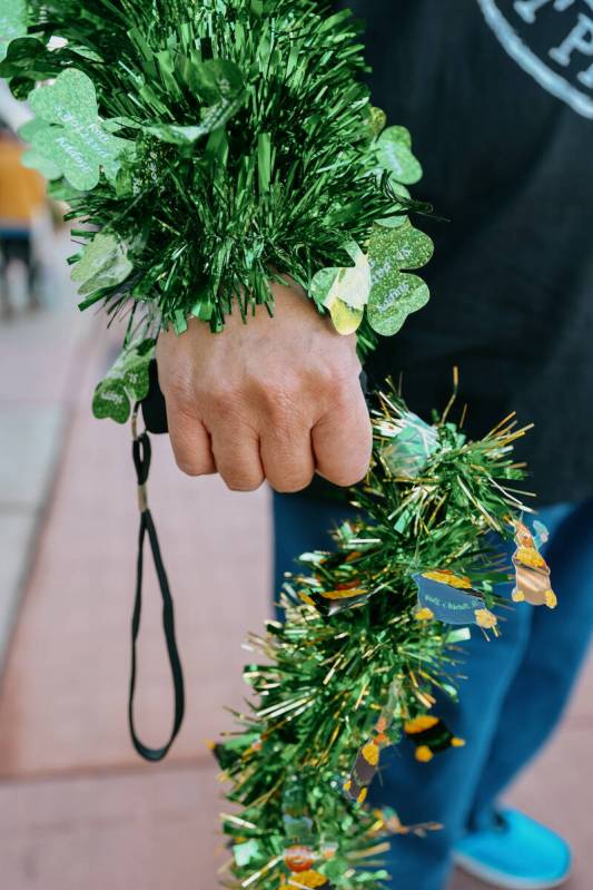 Raymond Martin holds his decked-out cane while wrapped in festive green garland before the annu ...
