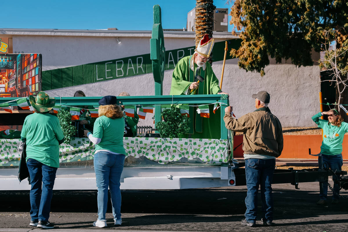 Scott Rice, dressed as St. Patrick, puts a few finishing touches on the structure of the float ...