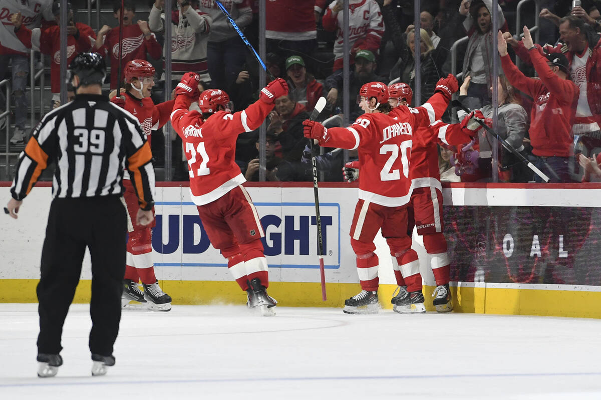 Detroit Red Wings players surround Lucas Raymond after he scored a goal against the Vegas Golde ...