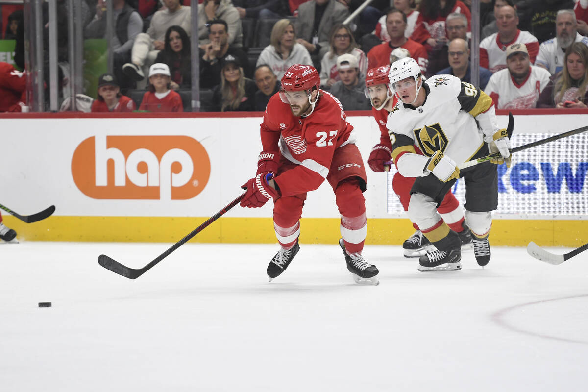 Detroit Red Wings center Michael Rasmussen, left, goes for the puck in front of Vegas Golden Kn ...