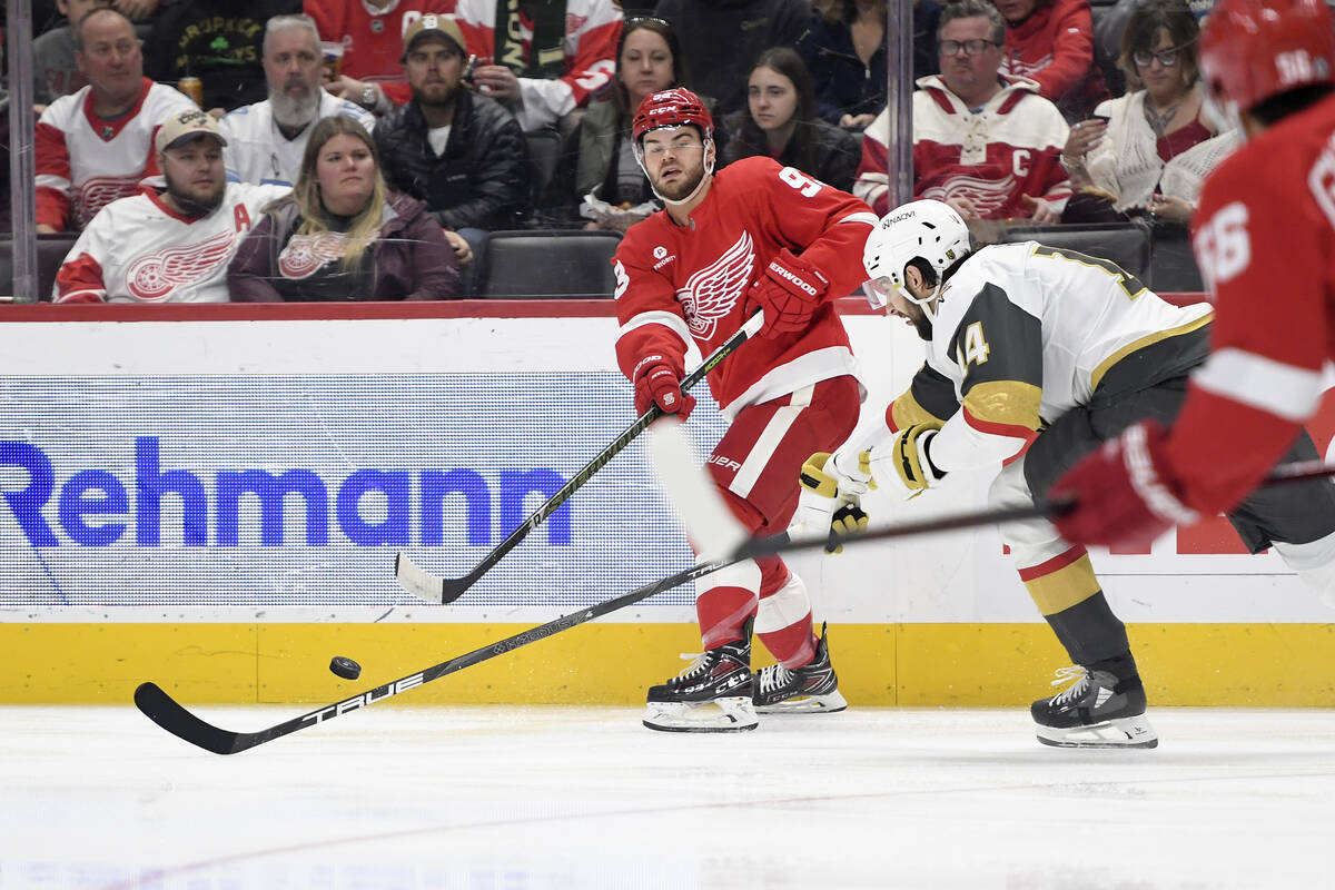 Detroit Red Wings right wing Alex DeBrincat, left, passes the puck away from Vegas Golden Knigh ...