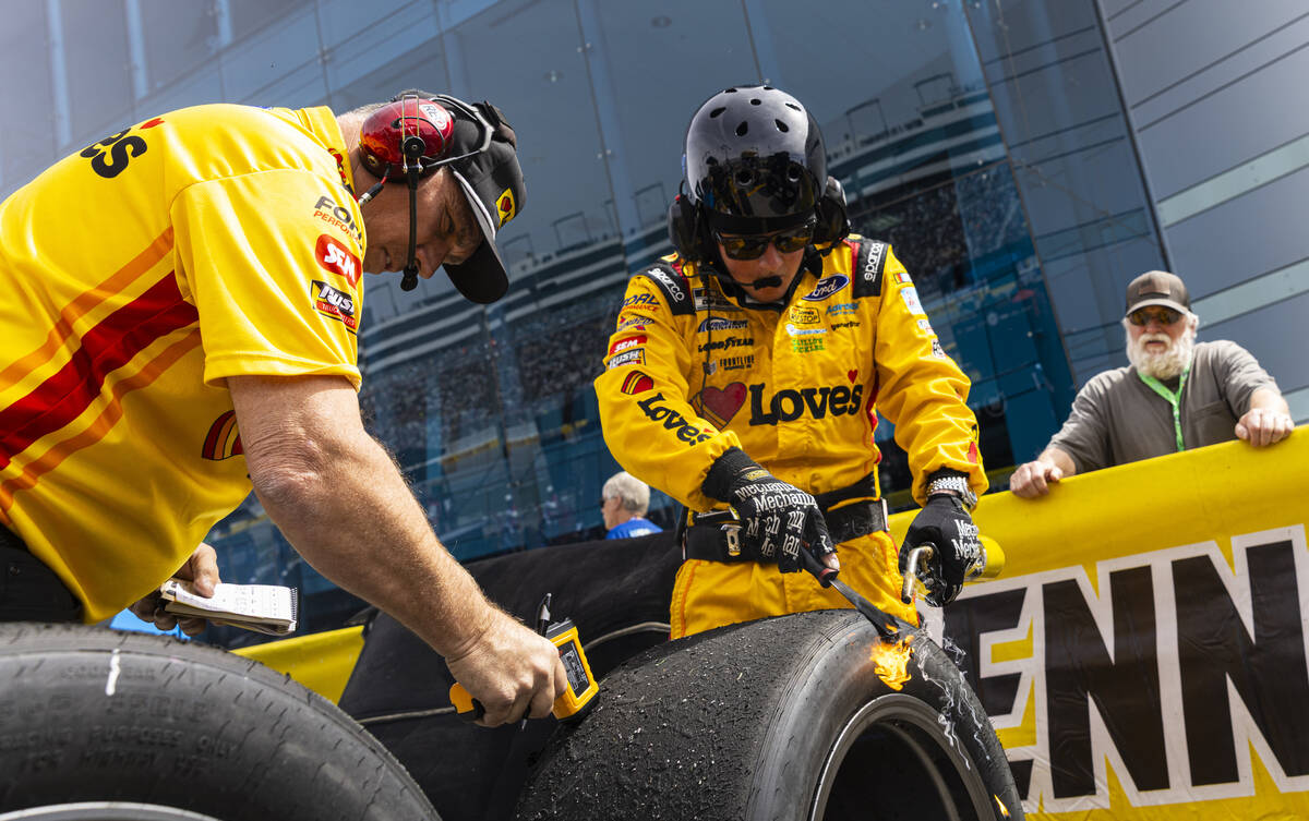 Pit crew members for driver Todd Gilliland (34) work on cleaning tires following a pit stop dur ...
