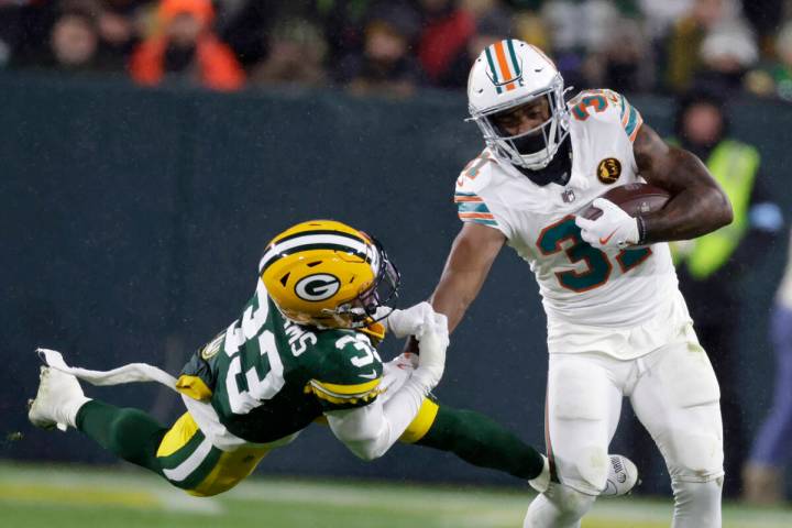 Miami Dolphins running back Raheem Mostert (31) tries to break a tackle by Green Bay Packers sa ...