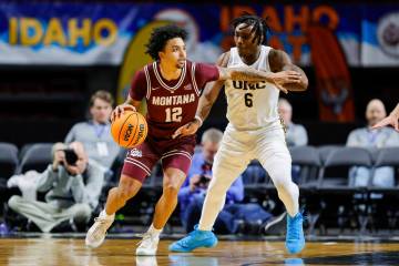 Montana guard Brandon Whitney (12) works the ball around the defense of Northern Colorado guard ...