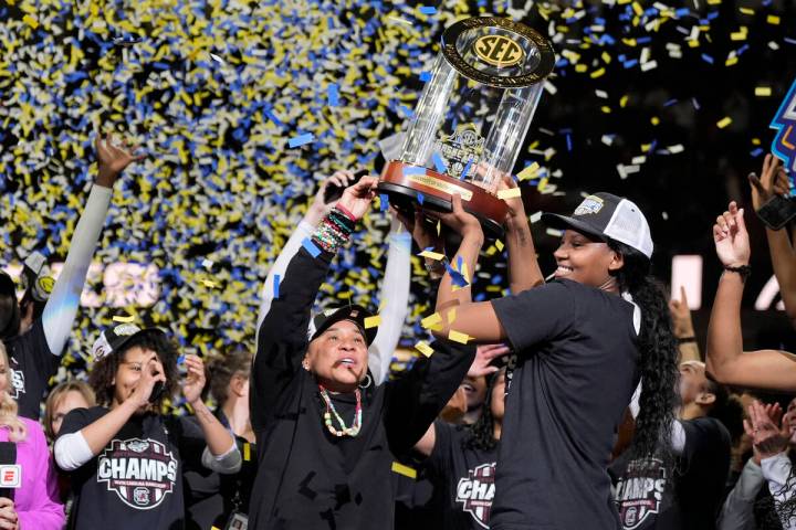 South Carolina head coach Dawn Staley holds the trophy with forward Sania Feagin after their wi ...