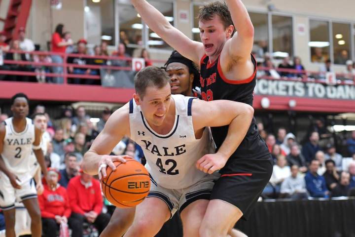 Yale forward Nick Townsend (42) drives in front of Cornell guard Jake Fiegen, right, and forwar ...