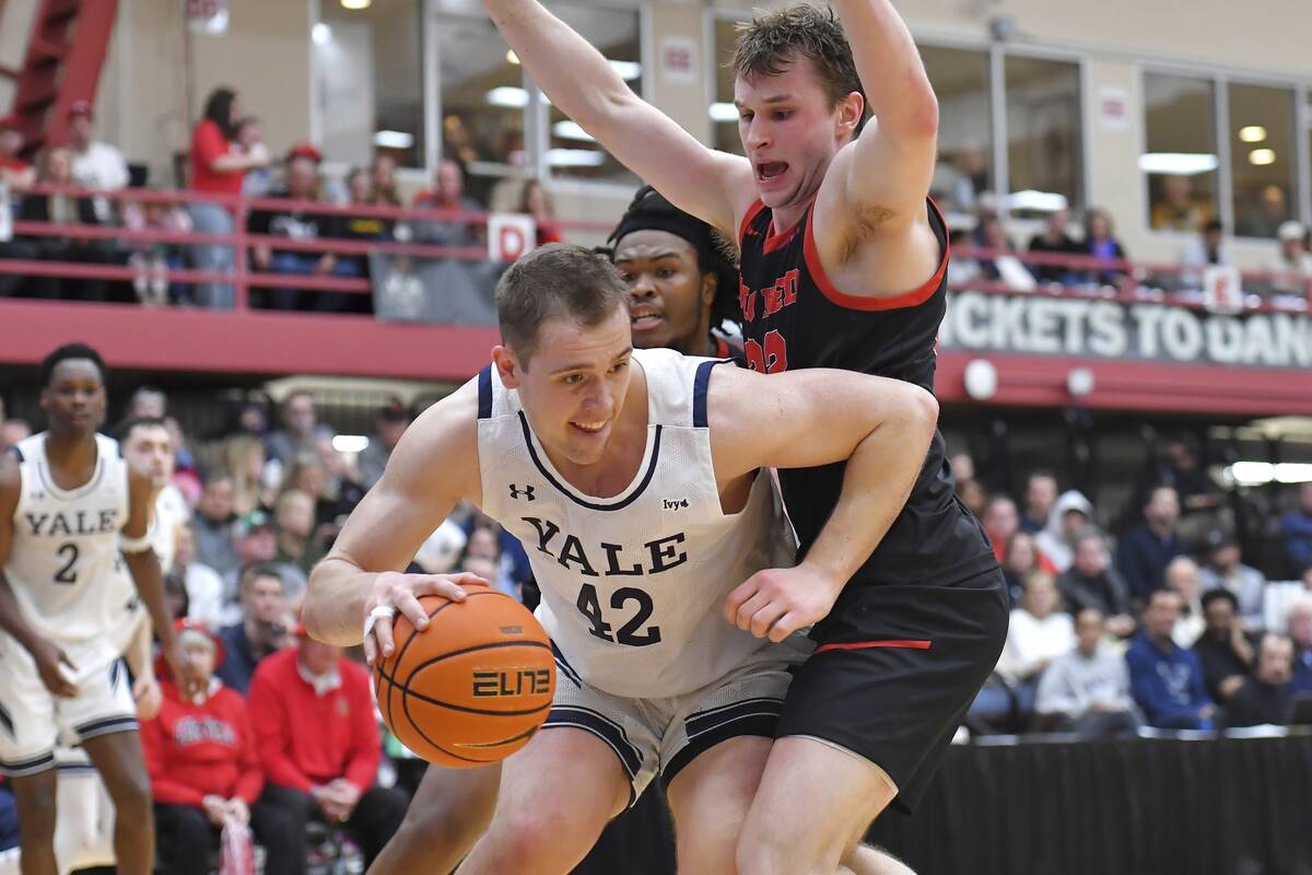 Yale forward Nick Townsend (42) drives in front of Cornell guard Jake Fiegen, right, and forwar ...