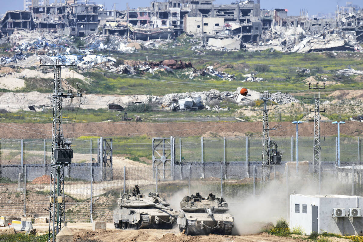 Israeli tanks maneuver on the border with northern Gaza Strip as seen from southern Israel, Tue ...