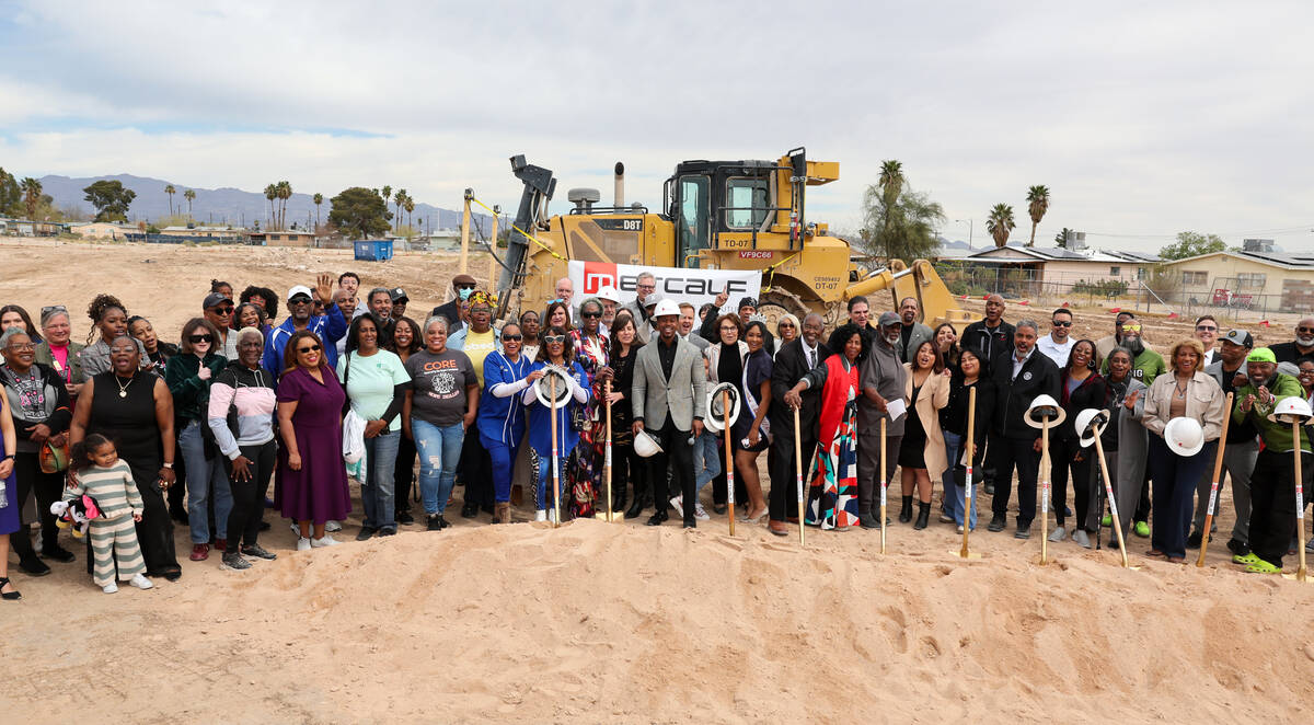 Dignitaries and guests pose during a groundbreaking ceremony on a mixed-use development combini ...