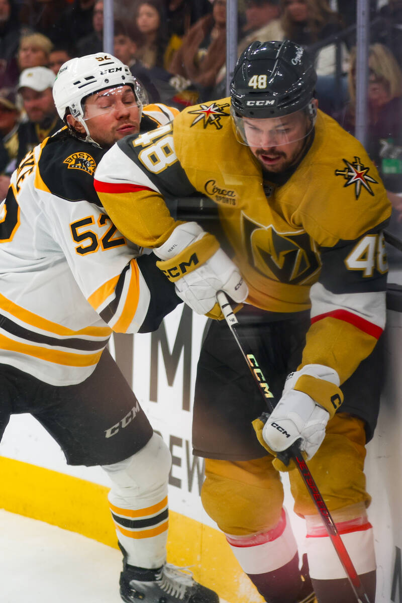 Golden Knights center Tomas Hertl (48) and Boston Bruins defenseman Andrew Peeke (52) fight for ...