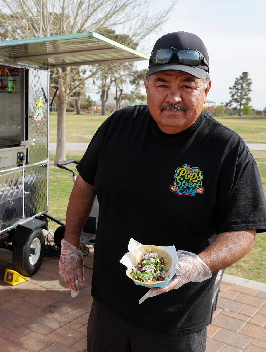 Jesus Rodriguez serves a customer from the Little Beans Cafe vending cart, previously known as ...