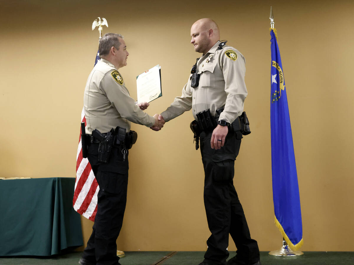 Metro officer Ryan Murphy shakes hands with Las Vegas Metro Police Undersheriff Andrew Walsh as ...