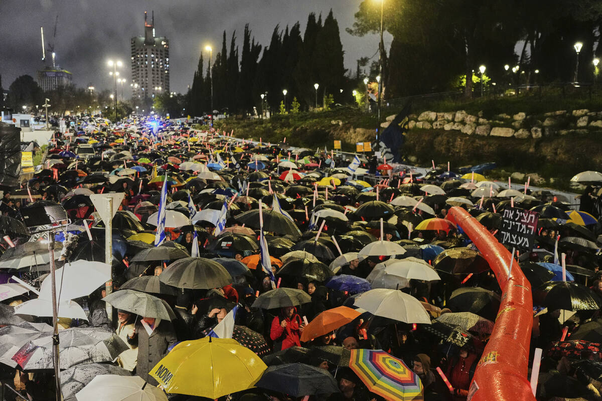 Israelis attend a rally against Prime Minister Benjamin Netanyahu's plan to dismiss the head of ...